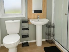 A bathroom with a toilet, sink, and shower at Littlesea Holiday Park - Holiday Accommodation 13127, Weymouth