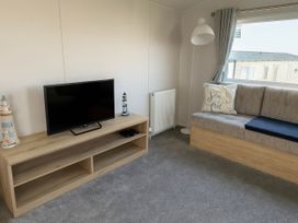 A living room with a television and sofa at Littlesea Holiday Park - Holiday Accommodation 13127 in Weymouth