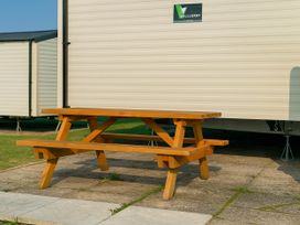 A picnic table in front of a caravan at Littlesea Holiday Park - Holiday Accommodation 13127 Weymouth