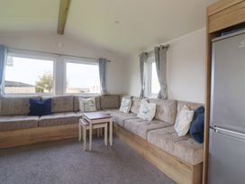 A living room with a sofa and table at Littlesea Holiday Park - Holiday Accommodation 13127 in Weymouth