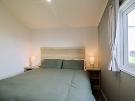 A bedroom with a bed and bedside table at Littlesea Holiday Park - Holiday Accommodation 13127 in Weymouth