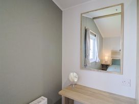 A bedroom with a mirror and a lamp at Littlesea Holiday Park - Holiday Accommodation 13127, Weymouth