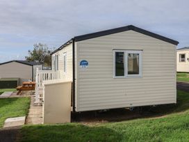 A mobile home with steps and grass at Littlesea Holiday Park - Holiday Accommodation 13127 Weymouth