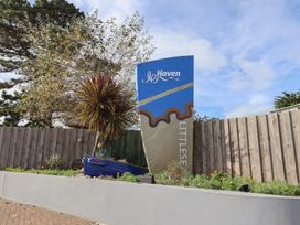A sign for Littlesea Haven with plants at Littlesea Holiday Park - Holiday Accommodation 13127, Weymouth