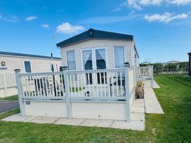 A static caravan with decking and windows at Golden Palm Resort - Holiday Accommodation 13363 Skegness