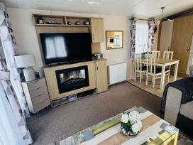 A living room with a television and dining table at Golden Palm Resort - Holiday Accommodation 13363 Skegness