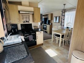 A kitchen with a stove and dining table at Golden Palm Resort - Holiday Accommodation 13363 Skegness