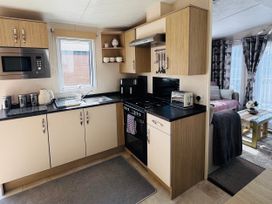 A kitchen with cabinets and appliances at Golden Palm Resort - Holiday Accommodation 13363 Skegness