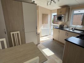 A kitchen with cabinets and a table at Golden Palm Resort - Holiday Accommodation 13363 in Skegness