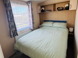 A bedroom with a bed and shelves at Golden Palm Resort - Holiday Accommodation 13363 in Skegness