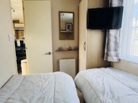 A bedroom with two single beds and a television at Golden Palm Resort - Holiday Accommodation 13363, Skegness