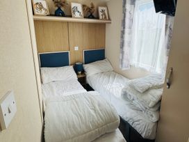 A bedroom with two single beds and a nightstand at Golden Palm Resort - Holiday Accommodation 13363 in Skegness