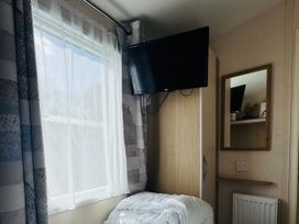 A bedroom with a bed and a television at Golden Palm Resort - Holiday Accommodation 13363 Skegness