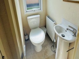 A bathroom featuring a toilet and sink at Golden Palm Resort - Holiday Accommodation 13363 Skegness