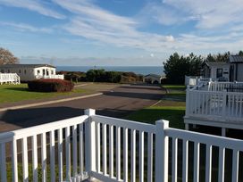 View from a deck overlooking holiday homes and the sea at Devon Cliffs Holiday Park - Holiday Accommodation 13607, Exmouth