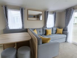 A living room with a sofa and table at Lyons Sunnysands Holiday Park - Barmouth