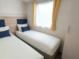 A bedroom with two beds and a window at Lyons Sunnysands Holiday Park - Holiday Accommodation 13733 Barmouth