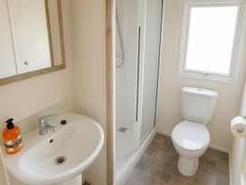 A bathroom with a wash basin and shower cabin at Reighton Sands Holiday Park - Holiday Accommodation 14875, Filey