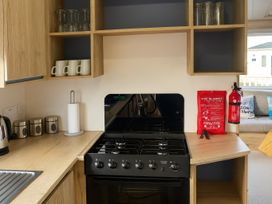 A kitchen with an oven, mugs and utensils at Reighton Sands Holiday Park - Holiday Accommodation 14875, Filey