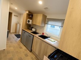 A kitchen with a sink and stove at Reighton Sands Holiday Park - Holiday Accommodation 14875, Filey