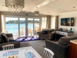A living room with a sofa and dining table at Lydstep Beach - Holiday Accommodation 14896, Tenby