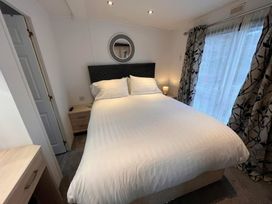 A bedroom with a double bed and nightstand at Lydstep Beach - Holiday Accommodation 14896 in Tenby