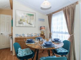 A dining room with a table set for four at Sunnysands in Talybont near Barmouth