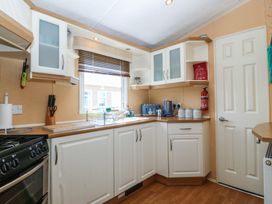 A kitchen with cabinets and appliances at Sunnysands in Talybont near Barmouth