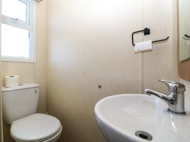 A bathroom with a toilet and sink at Sunnysands in Talybont near Barmouth