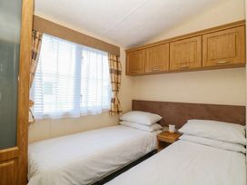 A bedroom with two beds and a window at Sunnysands in Talybont near Barmouth