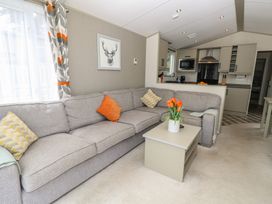 A living room with a sofa and coffee table at Pine Tree Lodge - Shorefield Country Park, Milford On Sea