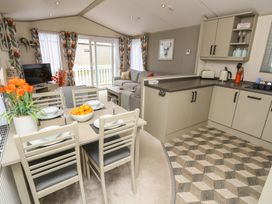 A living room with dining area and kitchen at Pine Tree Lodge - Shorefield Country Park Milford On Sea