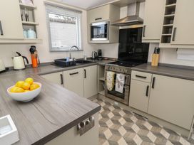 A kitchen with modern appliances and a fruit bowl at Pine Tree Lodge - Shorefield Country Park, Milford On Sea