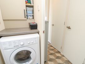 A laundry room with a washing machine and storage at Pine Tree Lodge - Shorefield Country Park Milford On Sea