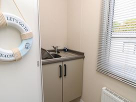 A utility room with a sink and a lifebuoy at Pine Tree Lodge - Shorefield Country Park, Milford On Sea