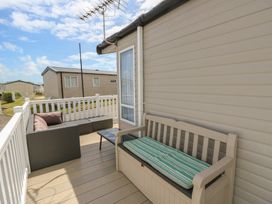 A porch with seating and a table at Pine Tree Lodge - Shorefield Country Park Milford On Sea