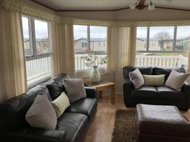 A living room with sofas and a table at Elie Holiday Park - Holiday Accommodation 15625, Elie