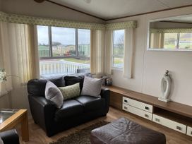 A living room with a sofa and coffee table at Elie Holiday Park - Holiday Accommodation 15625, Elie
