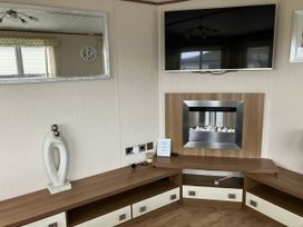 A living room with a television and a fireplace at Elie Holiday Park - Holiday Accommodation 15625 Elie