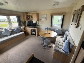 A living room with sofa, table and television at Thornwick Bay Holiday Village - Holiday Accommodation 15653, Bridlington