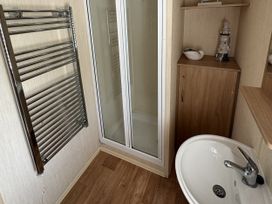 A bathroom with a shower, sink, towel rail and cabinet at Thornwick Bay Holiday Village - Holiday Accommodation 15653, Bridlington