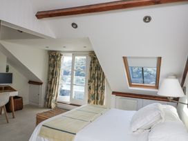 A bedroom with a bed, desk, and window at Fastnet at Nonsuch House, Kingswear, Devon