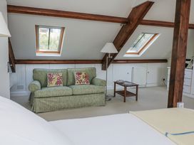 A bedroom with a sofa and window at Fastnet at Nonsuch House in Kingswear, Devon