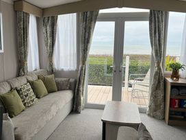 A living room with a sofa and cushions at Hafan y Mor Haven - Holiday Accommodation 16251 in Pwllheli
