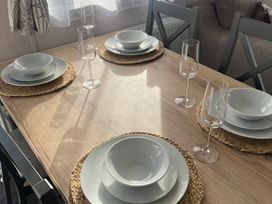 A dining table set with plates and glasses at Hafan y Mor Haven - Holiday Accommodation 16251, Pwllheli