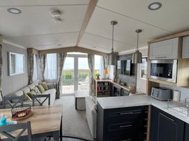 A living room with a sofa and dining table at Hafan y Mor Haven - Holiday Accommodation 16251 Pwllheli