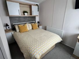 A bedroom with a double bed and shelves at Hafan y Mor Haven - Holiday Accommodation 16251 Pwllheli