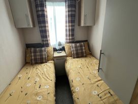 A bedroom with two single beds and a lamp at Hafan y Mor Haven - Holiday Accommodation 16251 Pwllheli