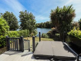 An outdoor area with a deck and a view of water at Tattershall Lakes Country Park - Holiday Accommodation 16408, Tattershall