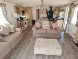 A living room with sofas and a kitchen area at Tattershall Lakes Country Park - Holiday Accommodation 16408 in Tattershall